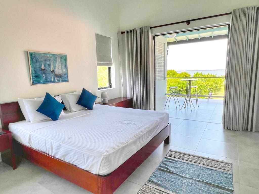 1 dormitorio con 1 cama grande y balcón en Villa Lagoonscape en Negombo
