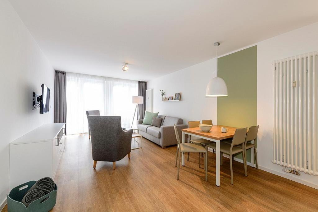 ein Wohnzimmer mit einem Tisch und ein Wohnzimmer mit einem Sofa in der Unterkunft Deichhäuser Anna Küste Deichhäuser Anna Küste 1-30 in Bensersiel