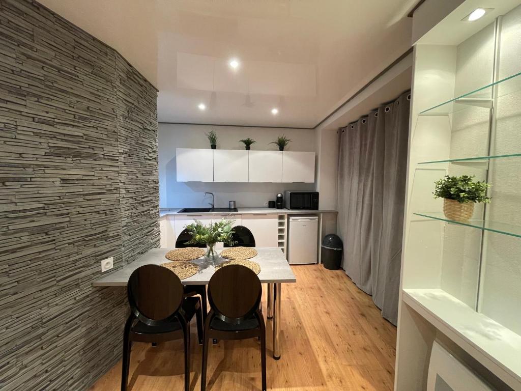 a kitchen and dining room with a table and chairs at Casa Jaubertie - Appartement cosy et chaleureux refait à neuf - HYPER CENTRE BRIVE in Brive-la-Gaillarde