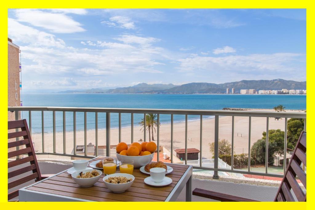 a table with fruit on a balcony with a view of the beach at Los Olivos Apartment Cullera in Cullera