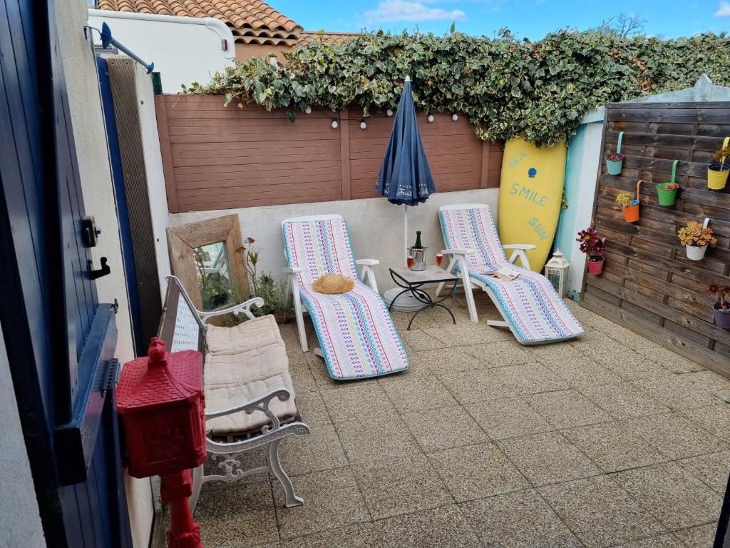 - une terrasse avec 2 chaises, une table et un parasol dans l'établissement Cosy kaz, à Bormes-les-Mimosas