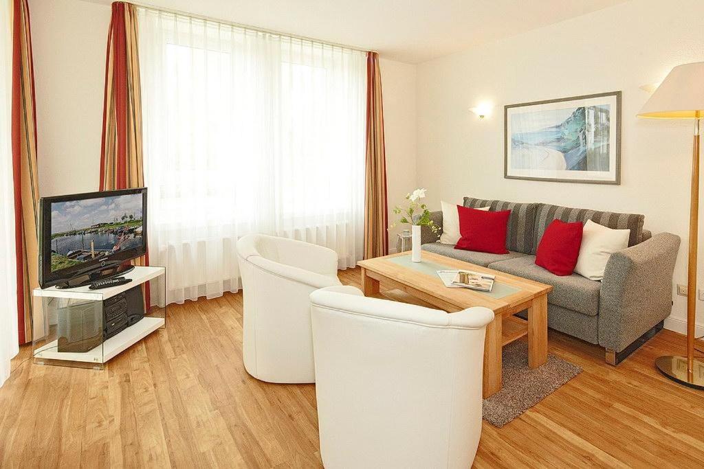 ein Wohnzimmer mit einem Sofa und einem TV in der Unterkunft Strand-Park Strand-Park 304 in Heringsdorf