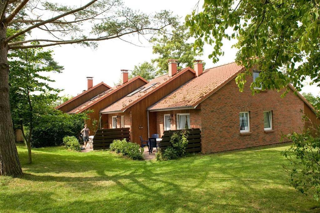 een groot bakstenen huis met een grasveld bij Urlauberdorf Urlauberdorf 43a in Boltenhagen