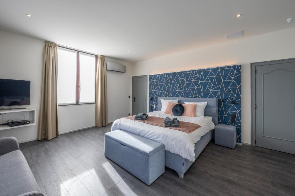 - une chambre avec un lit, un canapé et une télévision dans l'établissement Hotel Fi'Lin, à Machelen