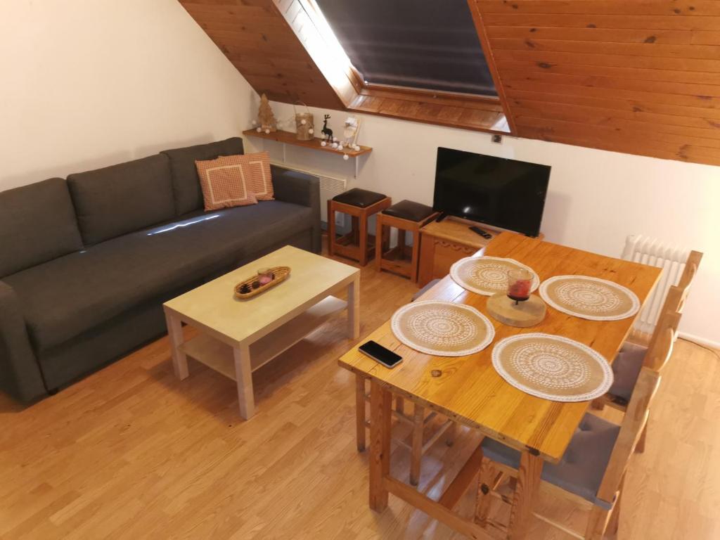 a living room with a table and a couch at Le petit Chalet Luchonnais in Luchon