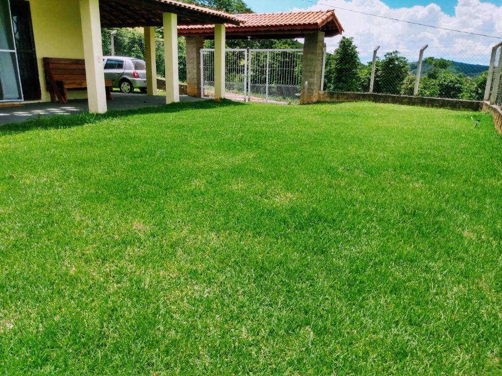 a yard with a fence and green grass at Recanto dos Cafezais in Bueno Brandão
