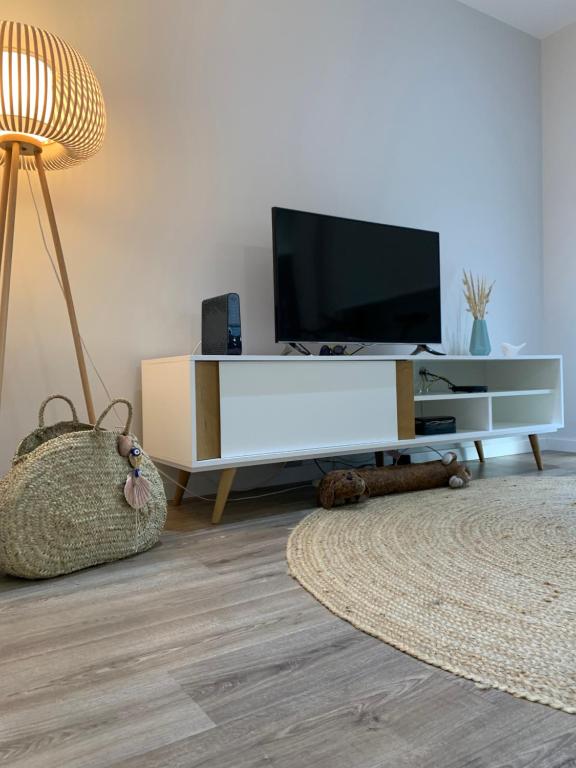 a living room with a flat screen tv on a cabinet at Foz Relógio Apartment in Figueira da Foz