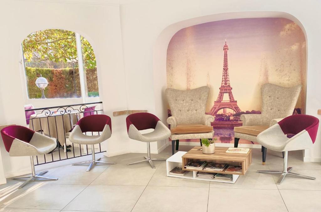 Hôtel D'orsay في أورس: غرفة بها كراسي وطاولة وبرج ايفل