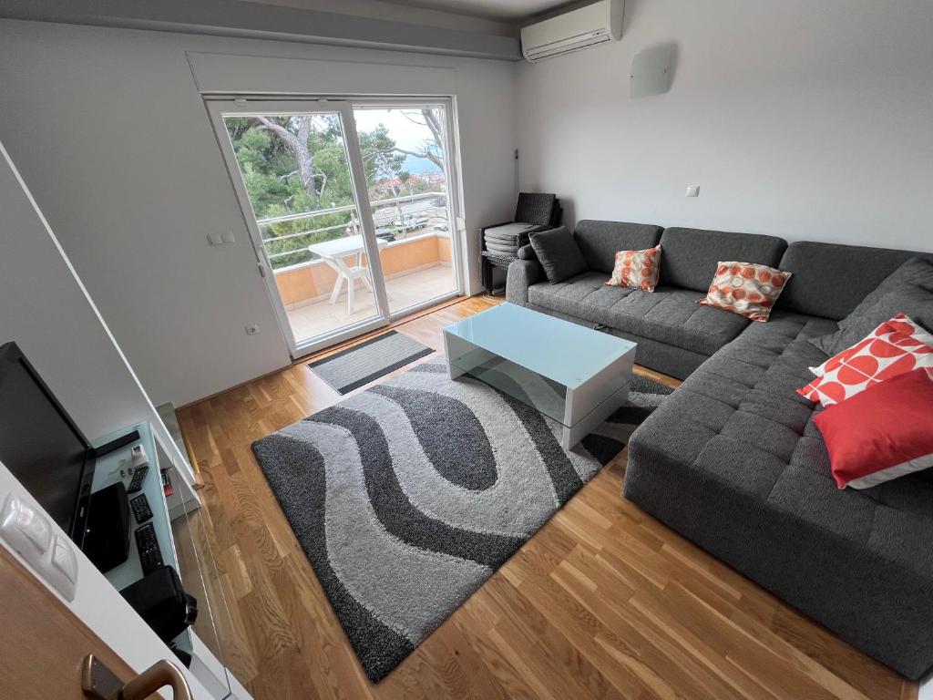 uma sala de estar com um sofá e uma mesa em Apartment Popeye em Makarska