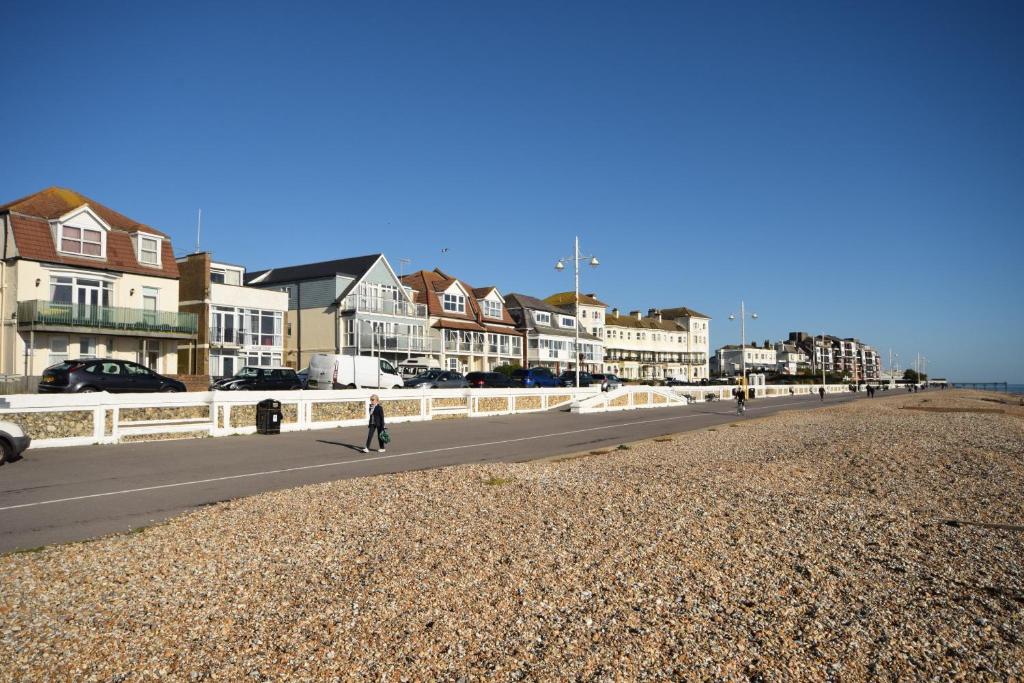 a person walking down a street next to a beach at Marine Court - Bognor Regis in Bognor Regis