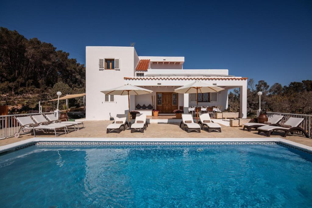 a villa with a swimming pool in front of a house at Villa Es Socorrat in Na Xamena
