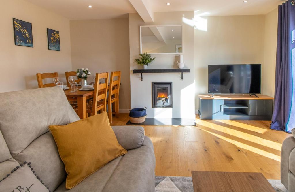 a living room with a couch and a table with a fireplace at Cottage On The Quay in Wroxham