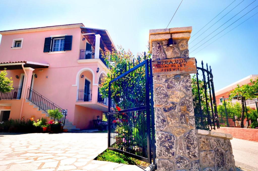 a gate in front of a pink house at Miranda Haus in Arillas