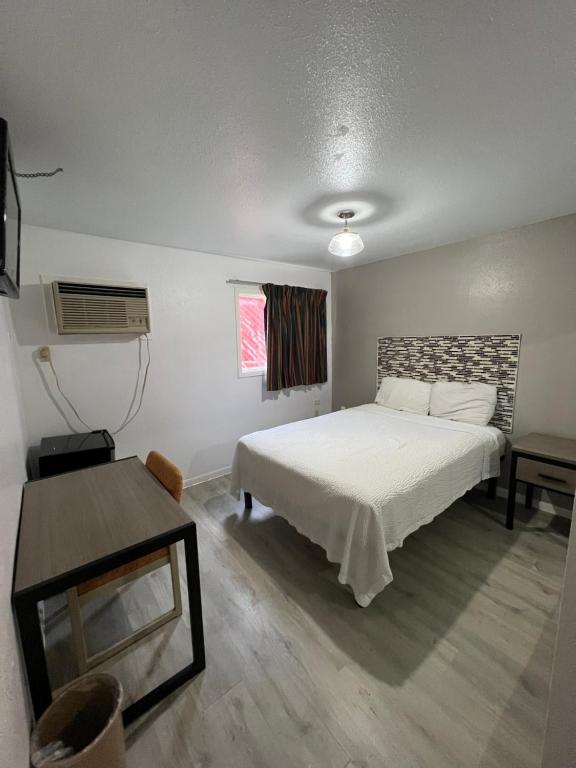 a bedroom with a white bed and a table at Best Inn Motel Seaworld & Lackland AFB in San Antonio