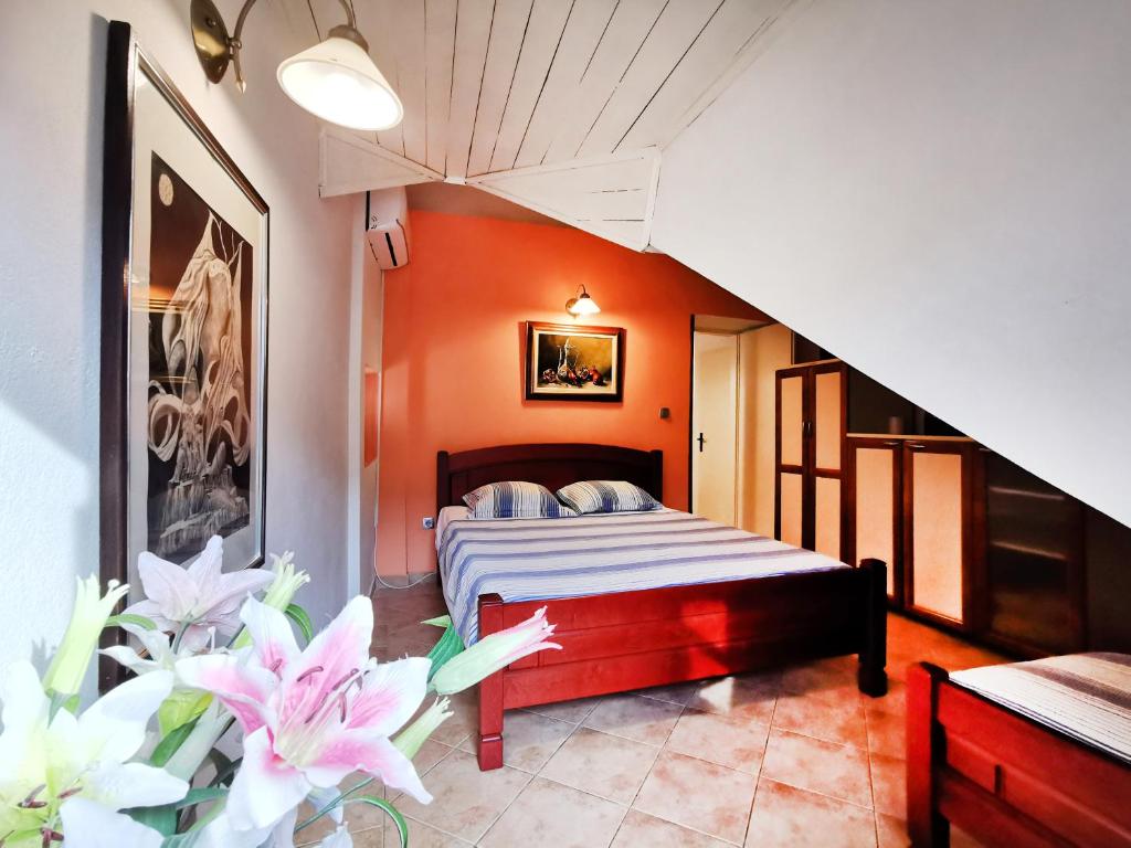 een slaapkamer met een bed met oranje muren en bloemen bij OLD TOWN 303 in Kotor