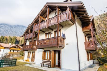 ein großes Gebäude mit Holzbalkonen darüber in der Unterkunft Le Marmotte del Brenta in Carisolo