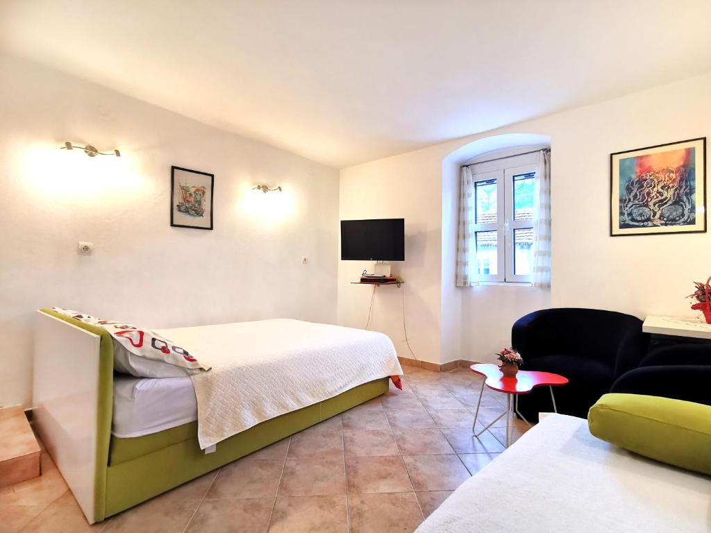 een slaapkamer met een bed en een woonkamer bij Old Town Boskovic Apartment in Kotor