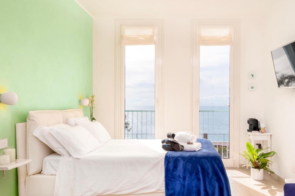 - une chambre avec un lit blanc et une table bleue dans l'établissement Camera Carolina, à Deiva Marina