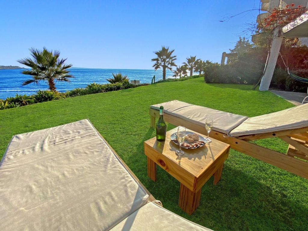 a picnic table with a bottle of wine and a plate of food at Puerto Velero Primera Línea Primer Piso al lado de la Playa! 5 pax in Puerto Velero