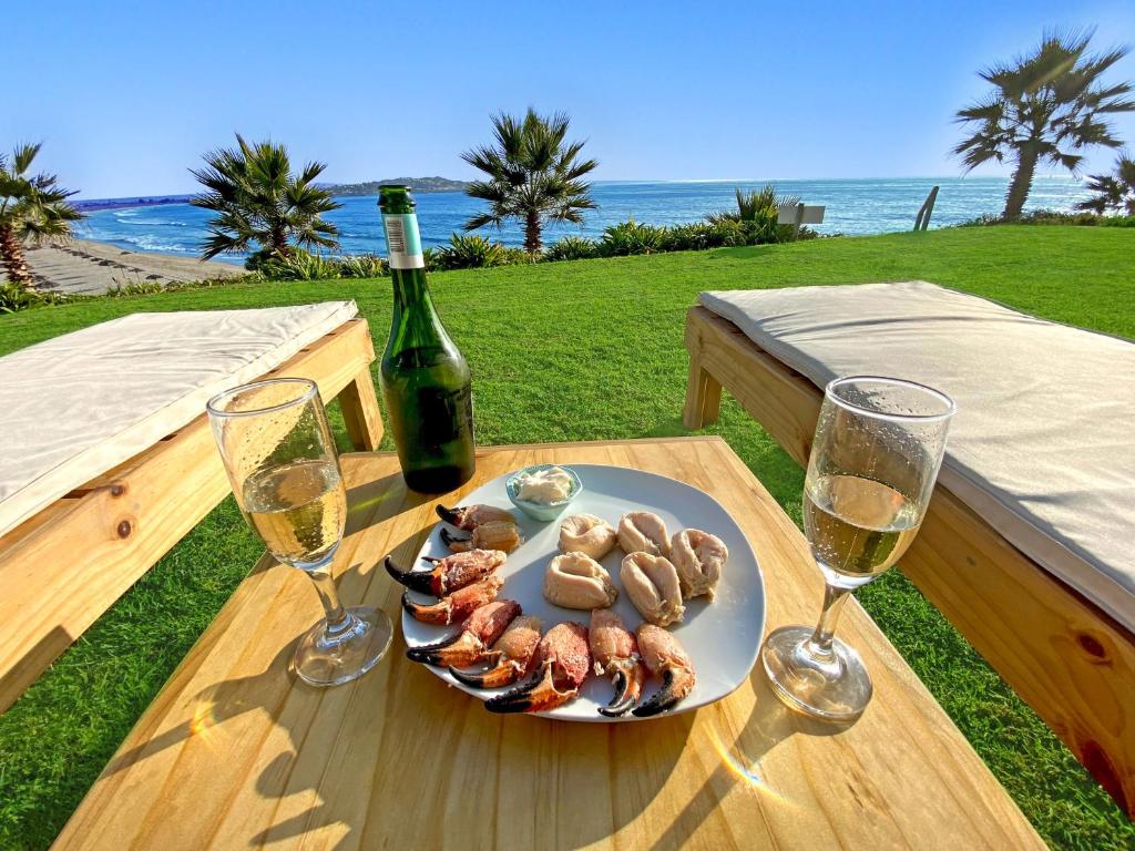 un plato de comida en una mesa con dos copas de vino en Puerto Velero Primera Línea Primer Piso al lado de la Playa! 8pax, en Puerto Velero