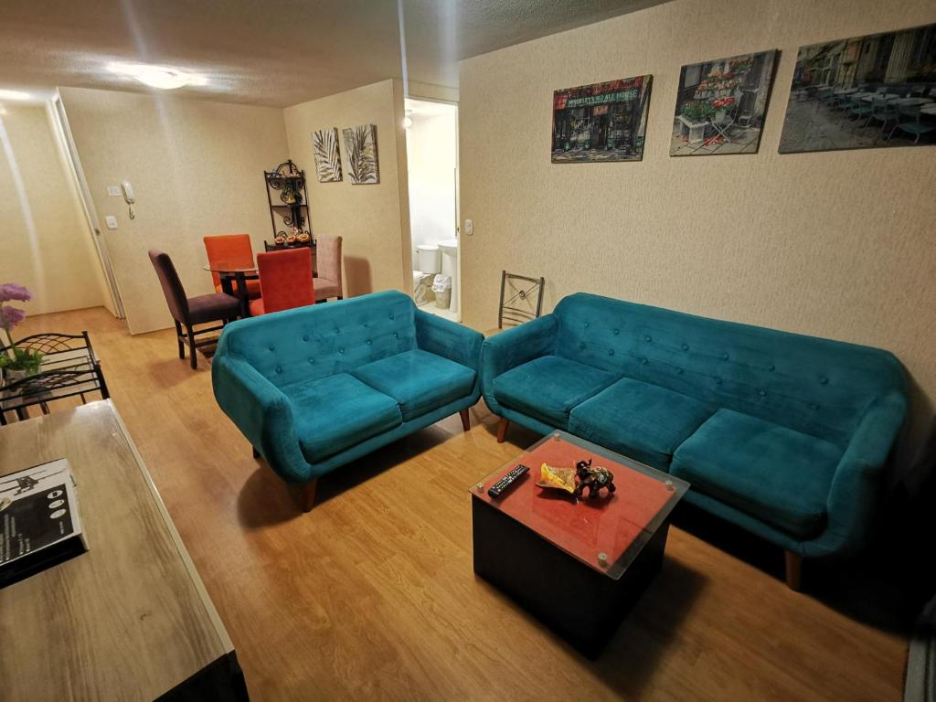 sala de estar con sofá azul y mesa en Departamento amoblado en condominio - 5to piso, en Tacna
