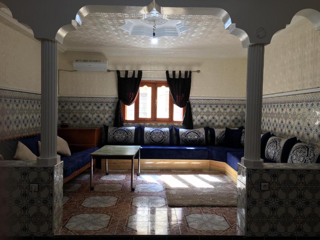 sala de estar con sofá azul y ventana en Senhaja Suite, en Targuist