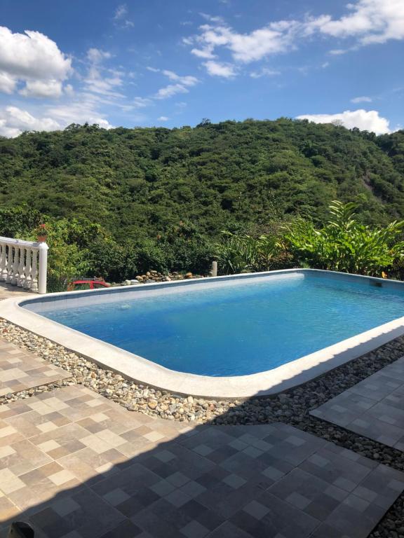 a swimming pool with a mountain in the background at FINCA FILANDIA in San Joaquín