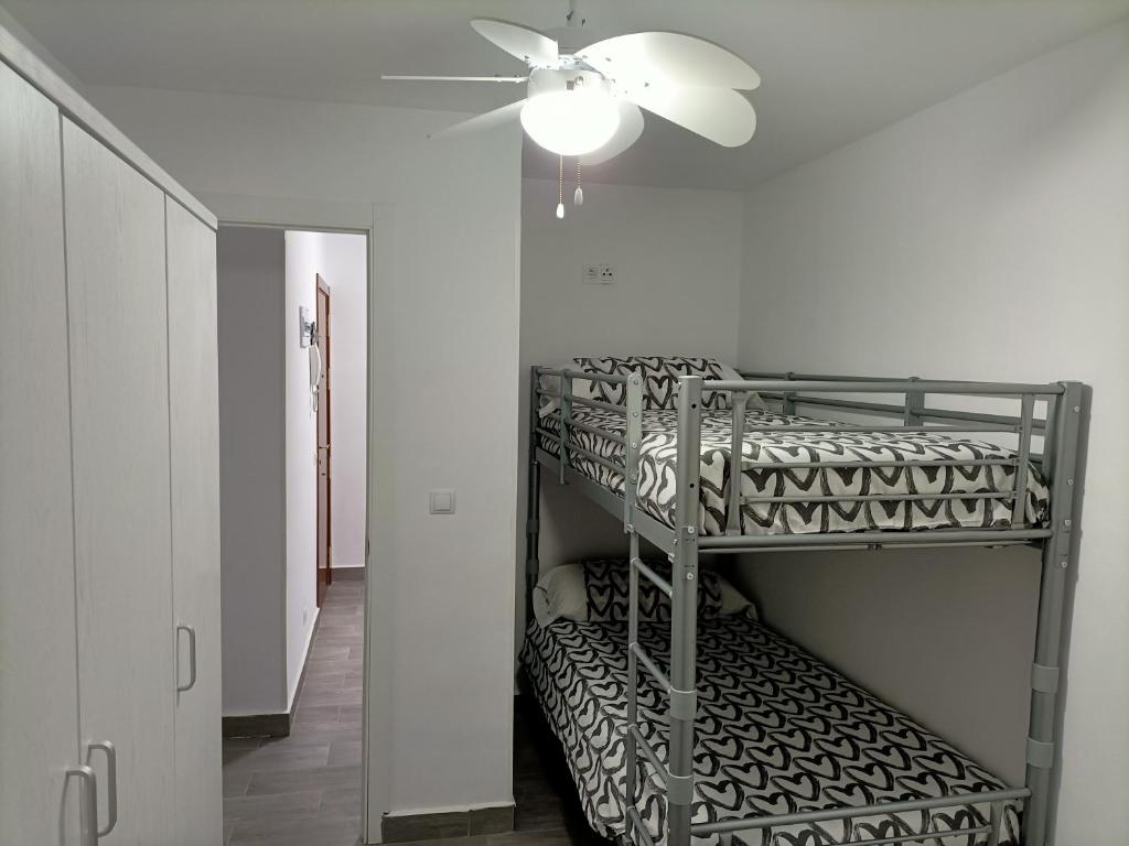 Habitación con escalera y ventilador de techo. en La Cubana con Aire Acondicionado, en Santa Pola