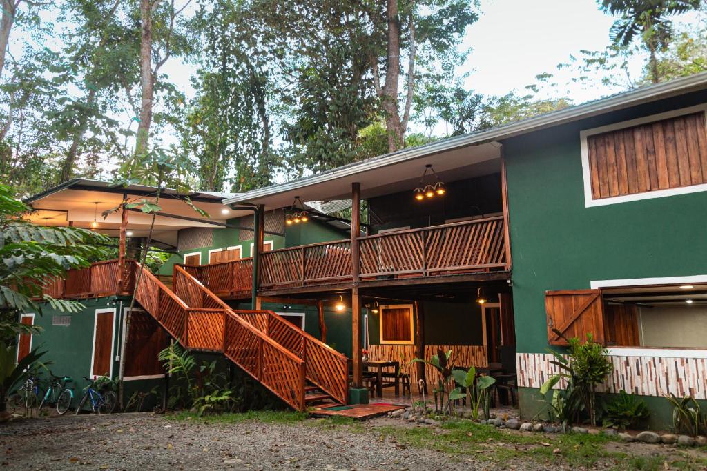 ein grünes Haus mit Holztreppe davor in der Unterkunft The Green Jungle & Tree House Caribe in Puerto Viejo