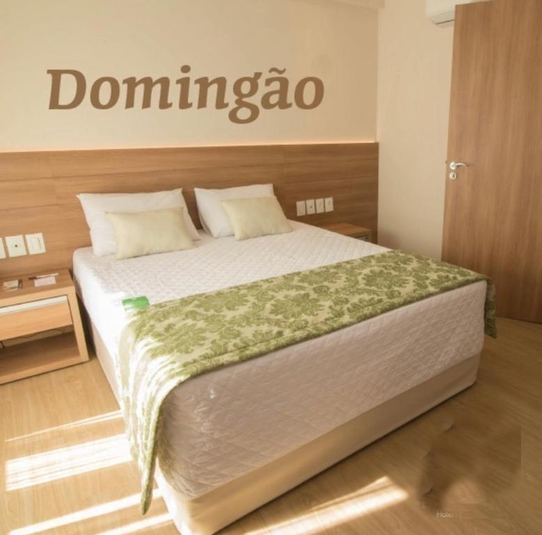 a bedroom with a bed with a sign on the wall at COND Vista azul hotel in Aracê