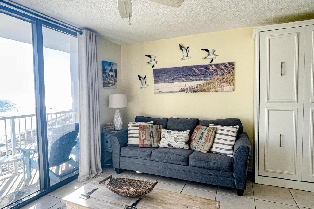 a living room with a couch and birds on the wall at Seaside Beach & Racquet Club 3605 in Orange Beach