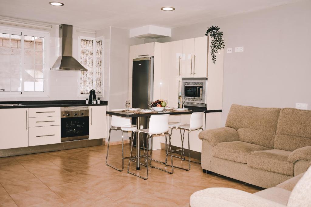 a kitchen and living room with a couch and a table at Casa Naihu in La Listada