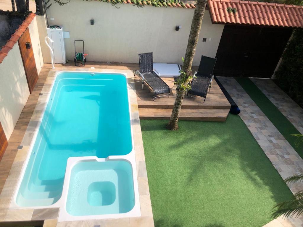 a swimming pool in the middle of a yard at Casa de praia, piscina aquecida, cervejeira e bilhar in Bertioga
