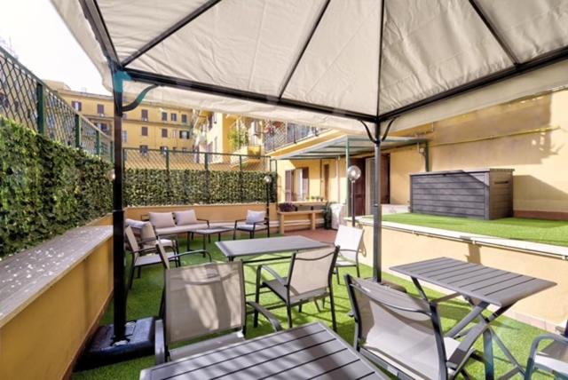 a patio with tables and chairs on a balcony at Vatican Rooms D’Angelica in Rome