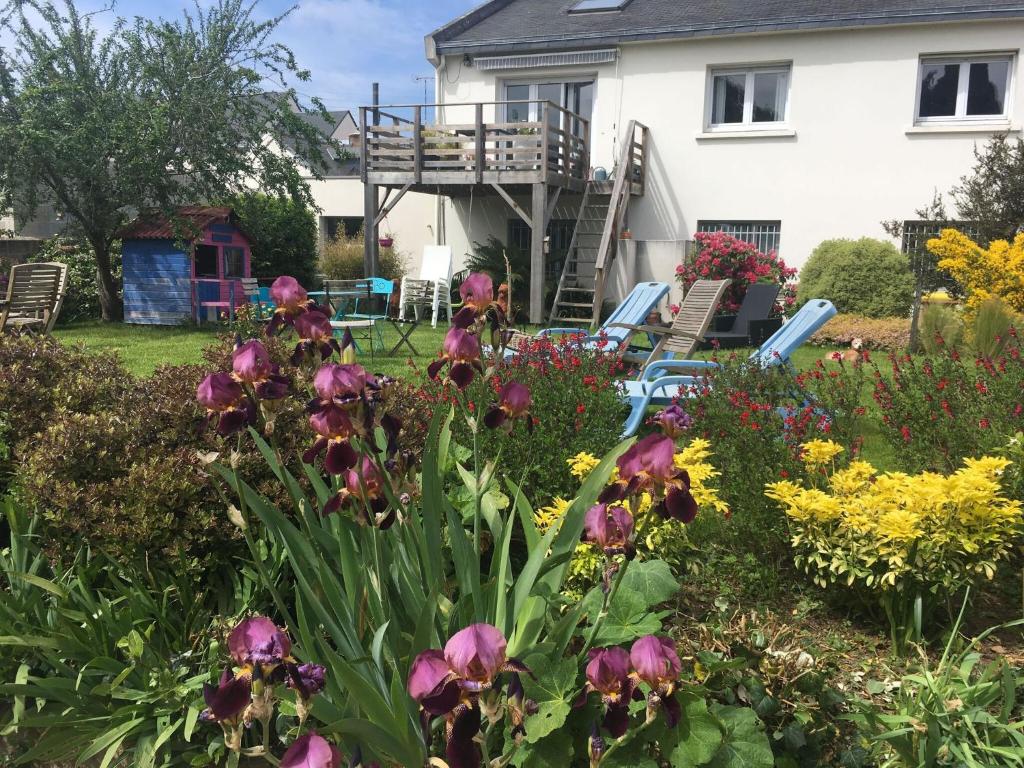 a garden in front of a house with flowers at Unusual duplex with garden in Saint-Brieuc