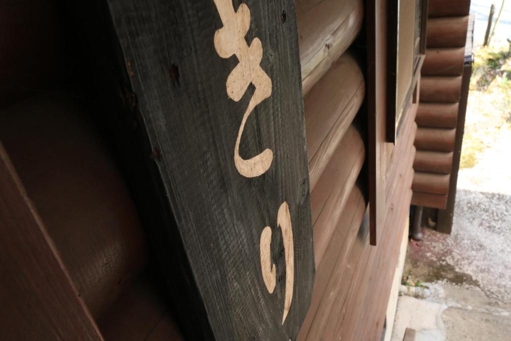 a wooden door with a sign on it at Kurasako Onsen Sakura in Minamioguni