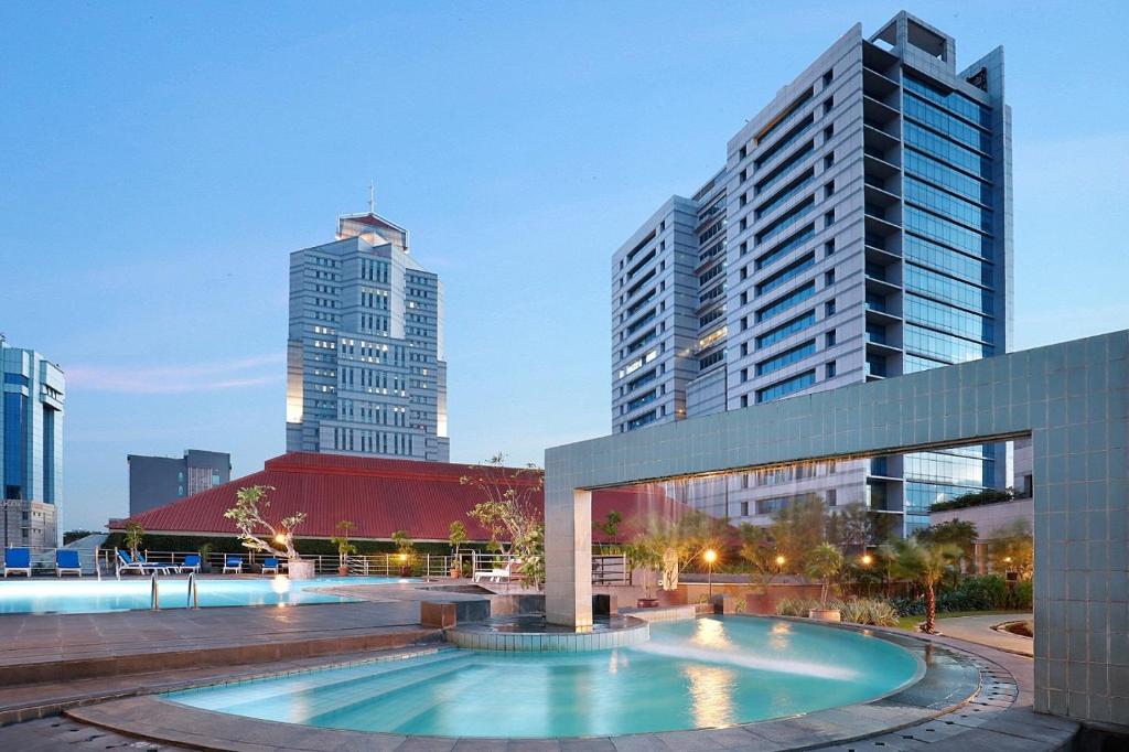 een zwembad in het midden van een stad met hoge gebouwen bij Hotel Bidakara Jakarta in Jakarta