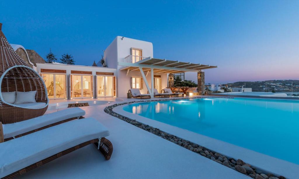a villa with a swimming pool at night at Luxury Ocean View Villa Mykonos Centre in Mikonos