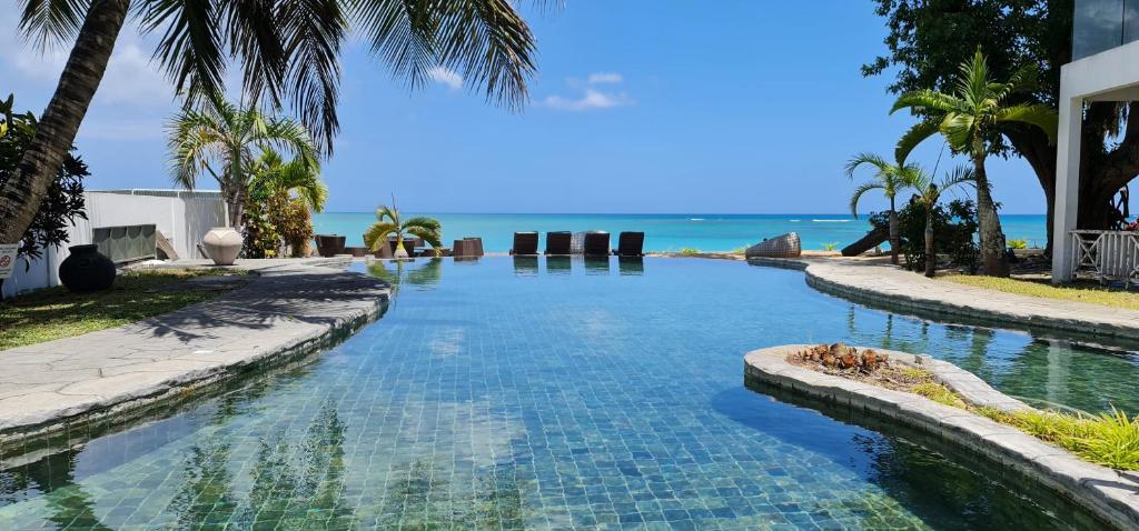 a swimming pool with the ocean in the background at Ocean Beauty in Pereybere