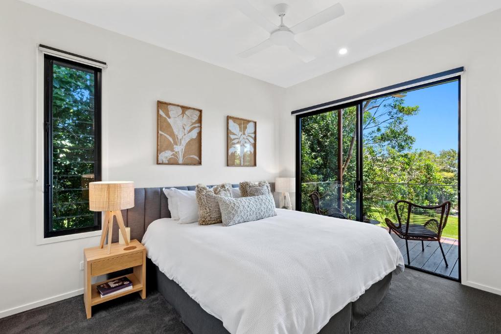 1 dormitorio con 1 cama grande y ventanas grandes en The Ridge at Maleny 1 Bedroom Villa with Spa, en Maleny