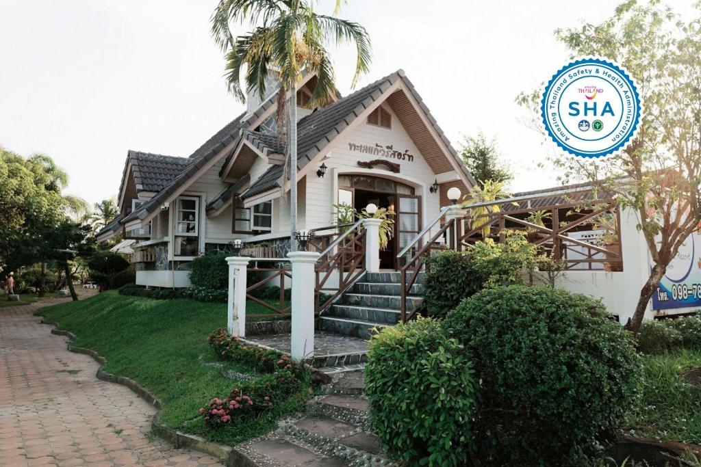 dom z palmą przed nim w obiekcie TaLeKaew Resort SHA w mieście Phitsanulok