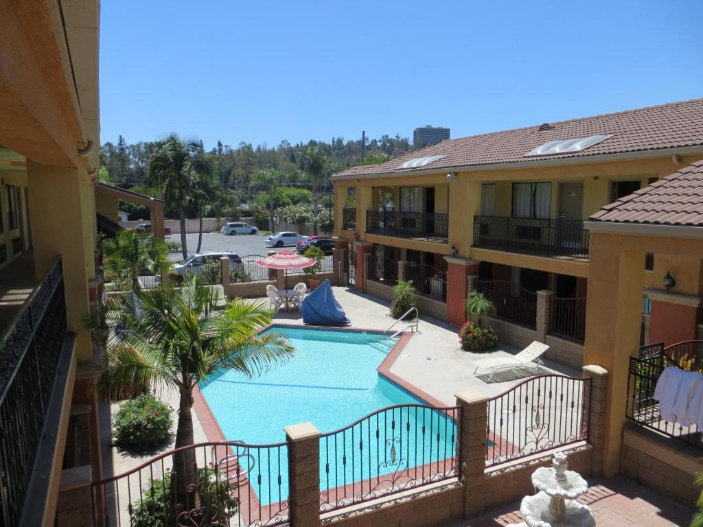 uma vista para a piscina a partir da varanda de um hotel em Azusa Inn em La Puente