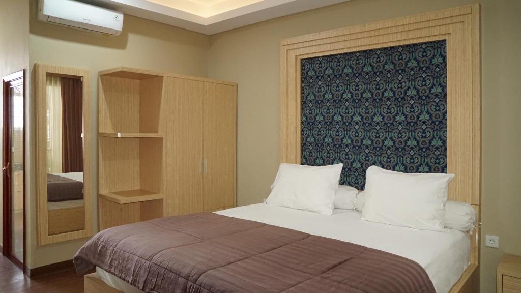 um quarto com uma cama com uma parede azul em Aldeoz Residence Kuta em Kuta