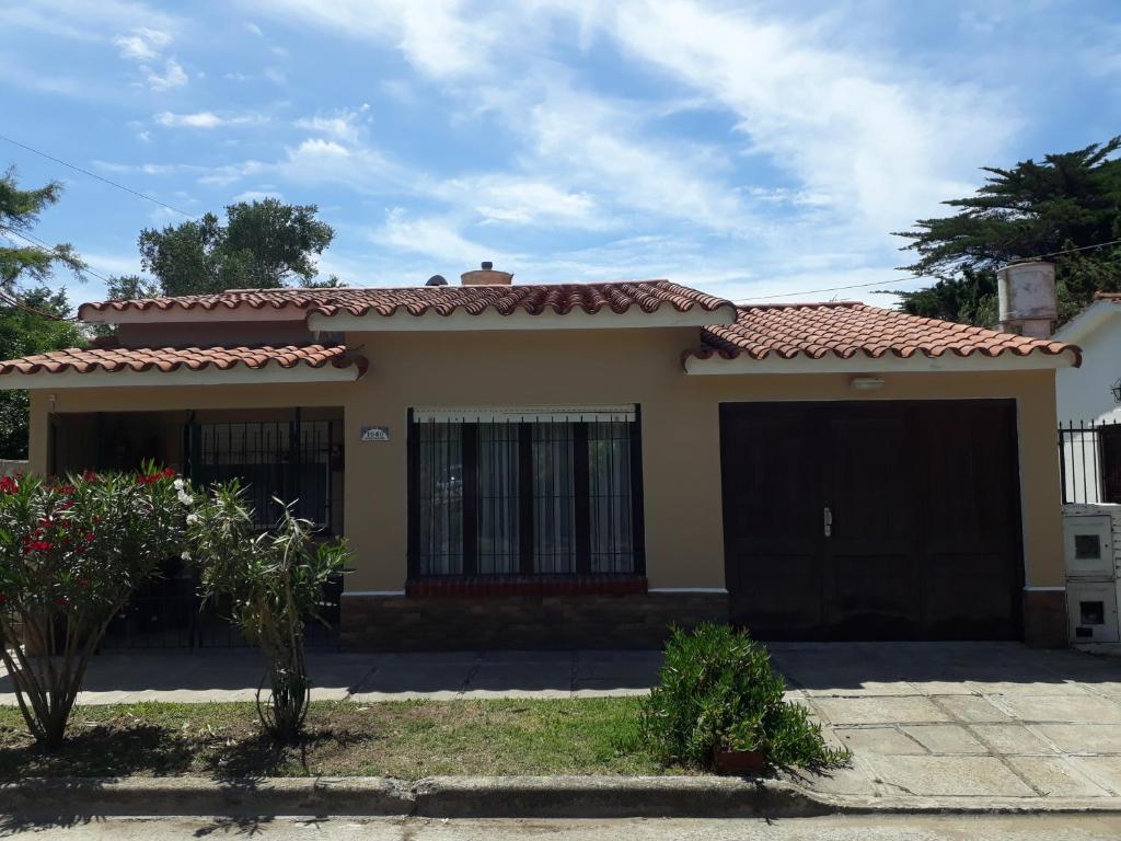 una pequeña casa amarilla con techo rojo en Chalet La Mambu, en Mar de Ajó