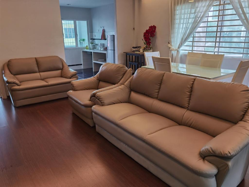 a living room with a leather couch and a table at My Sweet Home in Melaka