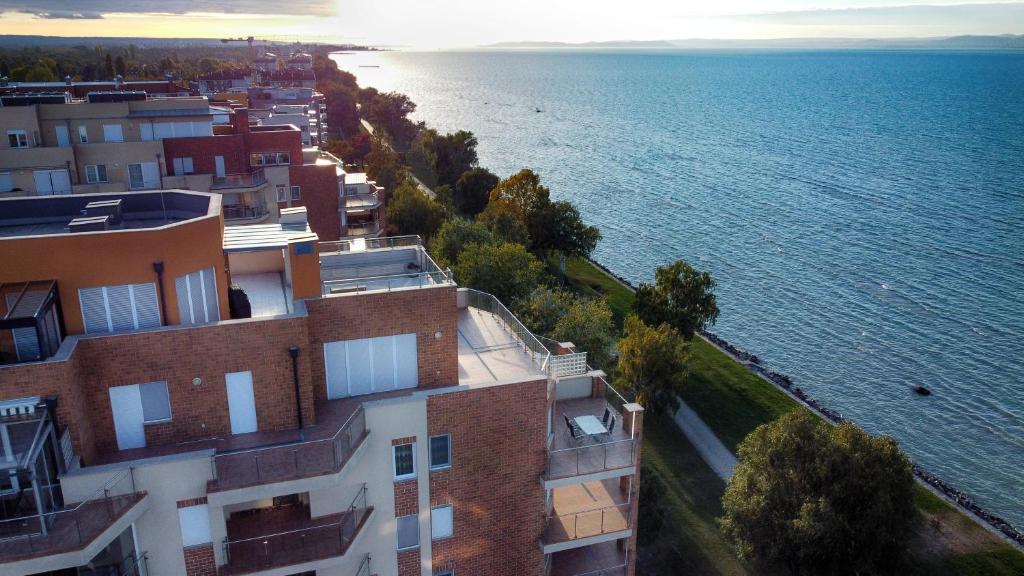 een luchtzicht op een gebouw naast het water bij Galerius Golden Beach Apartment in Siófok