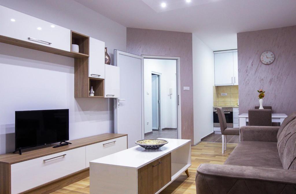 a living room with a couch and a flat screen tv at TOP Apartman in Šabac