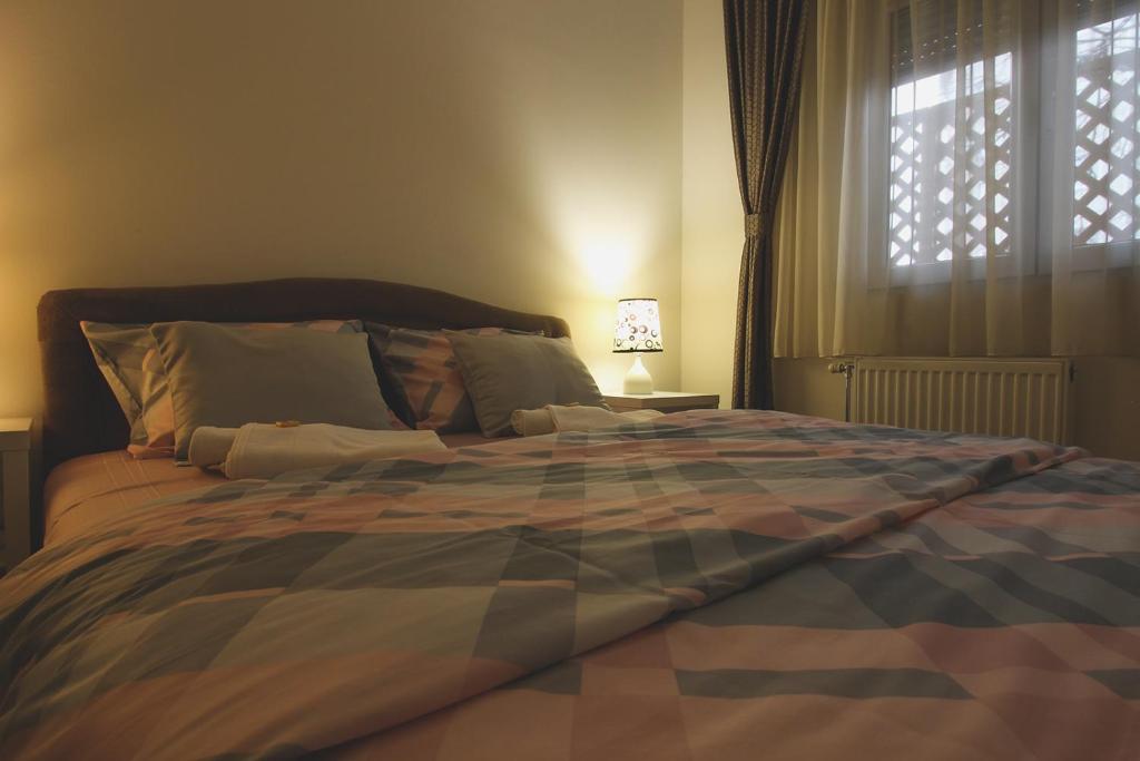 a large bed in a bedroom with a window at TOP Apartman in Šabac