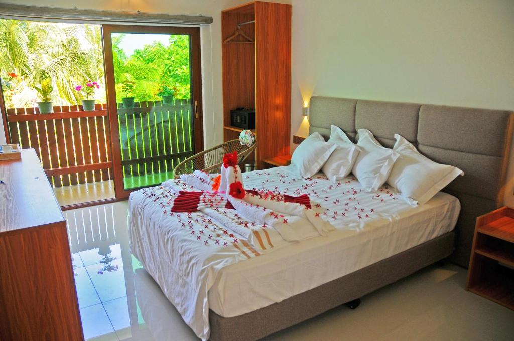 Postel nebo postele na pokoji v ubytování Palmrest Kaashidhoo Maldives