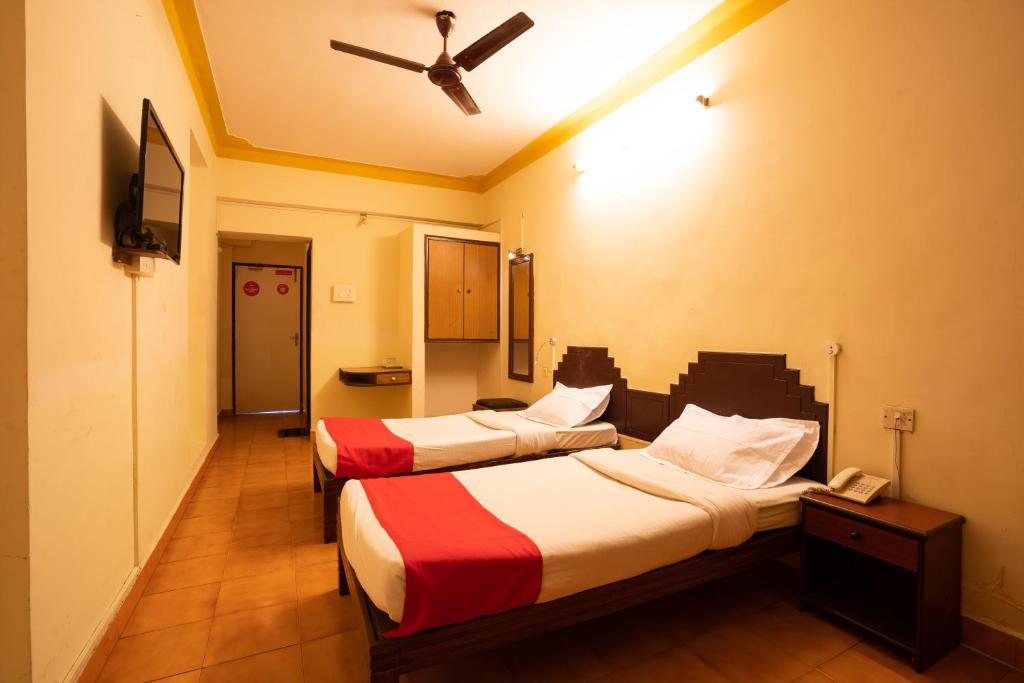 Habitación con 2 camas y ventilador de techo. en The Sincro Hotel en Madgaon